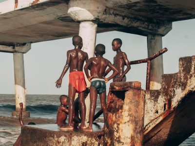 Children enjoying the seaside on a rustic pier in Malindi, Kenya, capturing a moment of summer freedom.